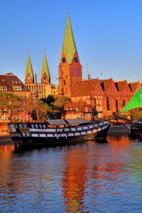 Historic sailing ship on the banks of the Weser river in front of the old town with Martini church and cathedral towers, Bremen, Land Bremen, Northern Germany, Germany Historic sailing ship on the banks of the Weser river in front of the old town with Martini church and cathedral towers, Bremen, Land Bremen, Northern Germany, Germany